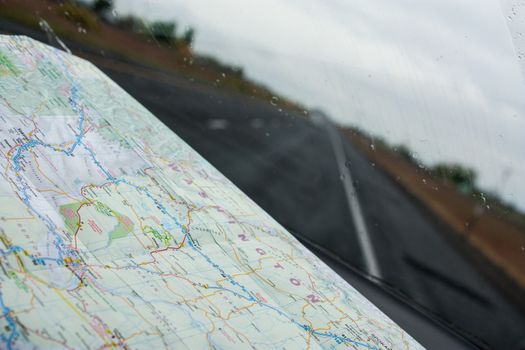 Looking through a windshield with a road map on the dashboard