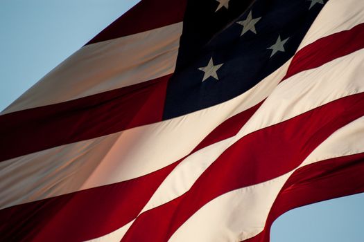 American flag close up with warm sunlight illuminating