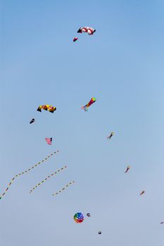 Colorful kites flying in the sky against a blue sky