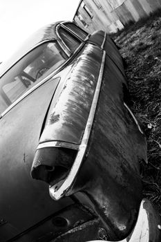 Antique vintage american automobile with a broken tail light in black and white