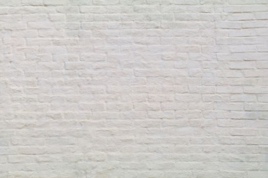 An old painted white brick wall shows.