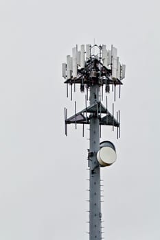 A hight capacity cell tower shows againtst the gray sky.