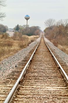Railroad tracks recede into the distance with a water tower showing in the background.