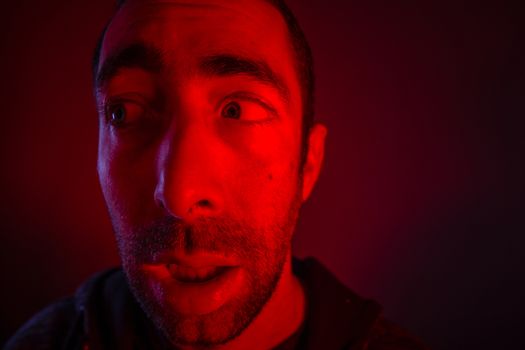 Man with shocked facial expression looking a side. Close up headshot portrait of nervous man.