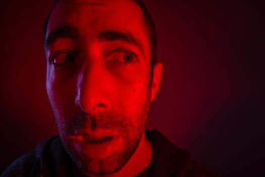 Man with shocked facial expression looking a side. Close up headshot portrait of nervous man.