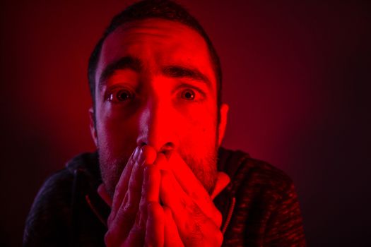Stunned frightened man with surprised facial expression. Close up headshot portrait of shocked man with his hand on the face.