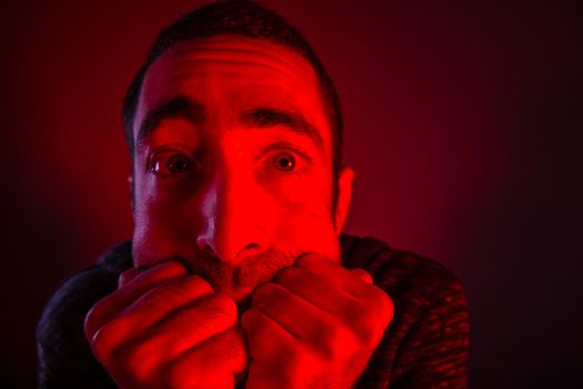 Stunned frightened man with surprised facial expression. Close up headshot portrait of shocked man with his hand on the face.
