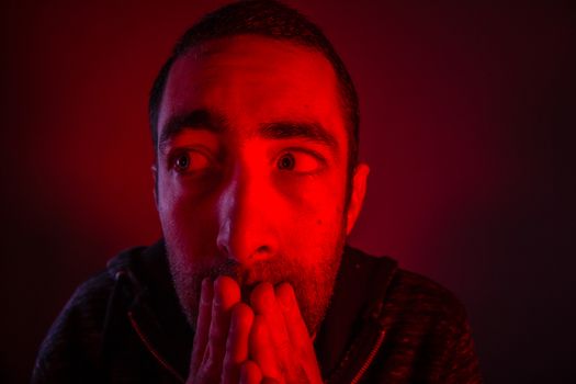 Stunned frightened man with surprised facial expression. Close up headshot portrait of shocked man with his hand on the face.