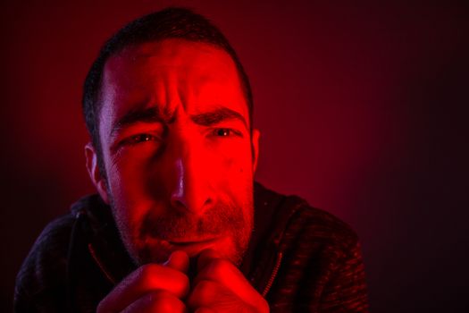 Man with terrified facial expression. Close up headshot portrait of crying man with his hand on the face.