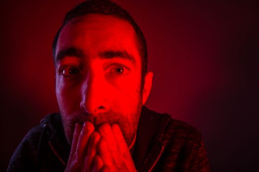 Stunned frightened man with surprised facial expression. Close up headshot portrait of shocked man with his hand on the face.