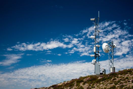 Mountain top weather station with a blue sky and scattered clouds