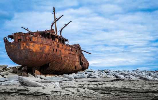 Ship wreck onshore in Aran Island. Rusted ship wreck has been brought far onshore by a storm on rocks.