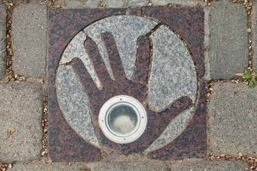 Paving flagstone with open hand in Uzupis, art district in Vilnius, Lithuania