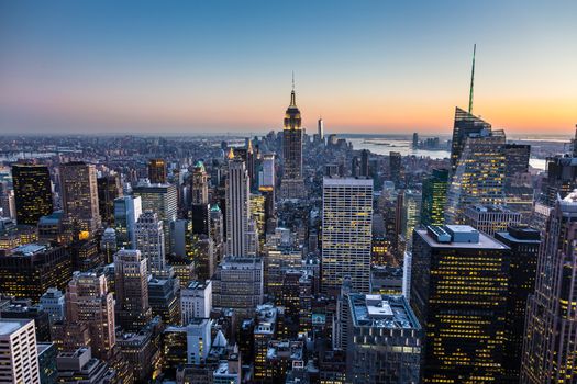 New York City. Manhattan downtown skyline with illuminated Empire State Building and skyscrapers at dusk. USA.