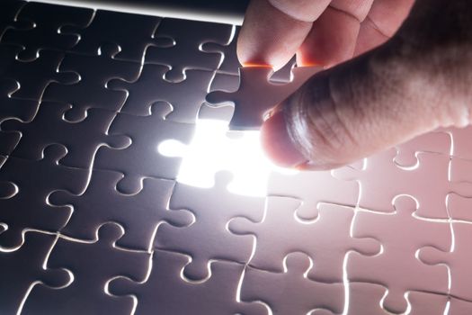 Male or Man Hand and Finger put Piece of Jigsaw in Place to Solve or Match Puzzle as Business Solution