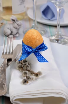 Decorations for Easter.   Golden egg  cups tied with a ribbon on a napkin.  