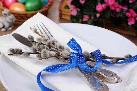Decorations for Easter. Knife and fork with pussy-willow branches tied with ribbon on a napkin