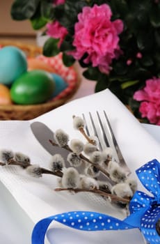 Decorations for Easter. Knife and fork with pussy-willow branches tied with ribbon on a napkin
