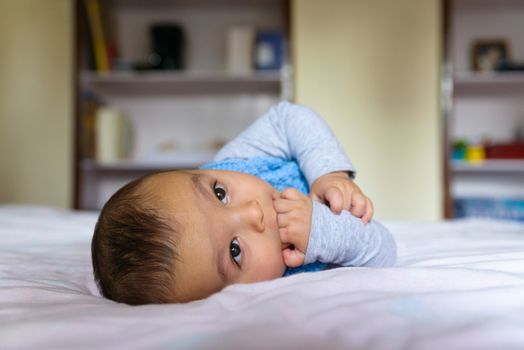 Eurasian baby lying on bed