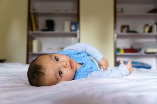 Eurasian baby lying on bed