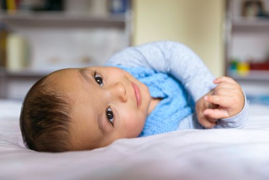 Eurasian baby lying on bed