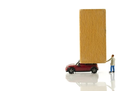 big wooden block on small red car as icon for transport by man