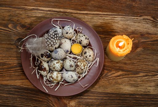 fresh quail eggs in a plate on a wooden background