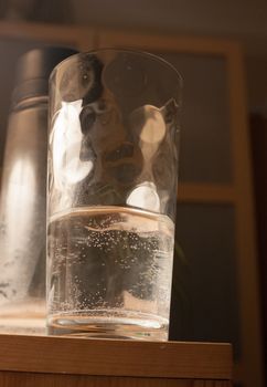 close up of half filled glass of water on side ; essex; england; uk