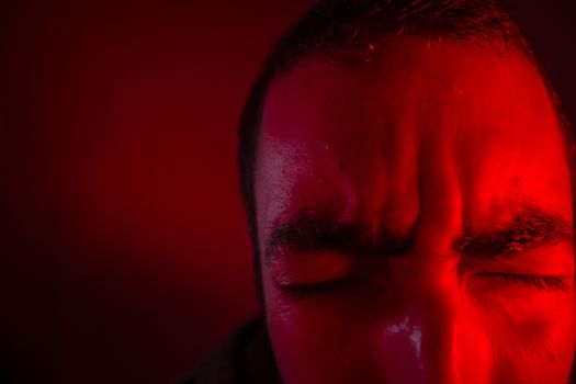 Man is suffering from pain or grief. Close up headshot portrait of man feeling upset or in pain.