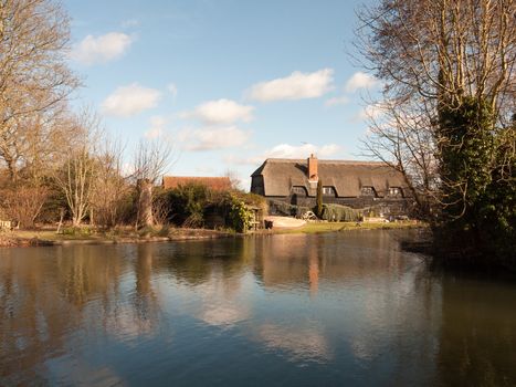 flatford black farm house mill house cottage from across the water; essex; england; uk