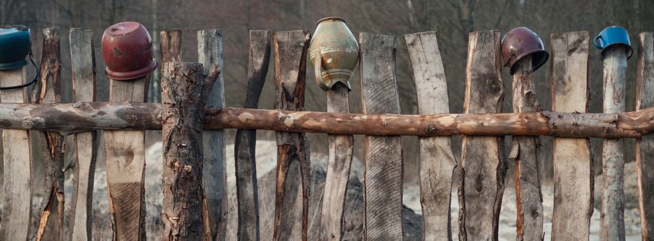 Old wooden boundary fence with nails on sunny day