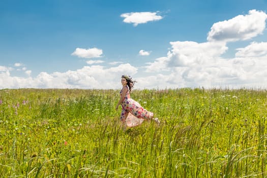 Portrait of the beautiful girl running in the field