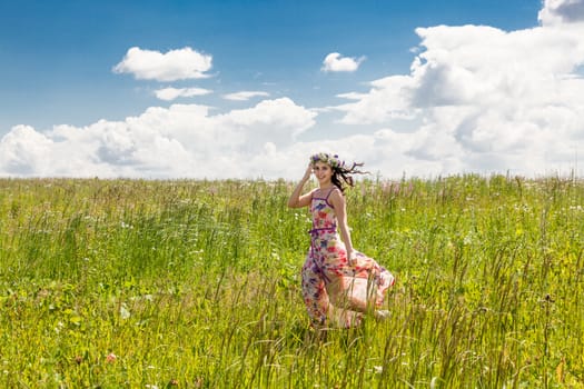 Portrait of the beautiful girl running in the field