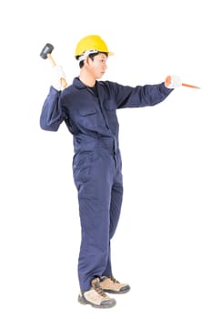 Young man in uniform sit and holding hammer was nailed to a cold chisel, Cut out isolated on white background