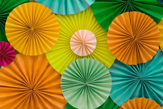 Colorful celebration background wall with multicolored paper circles of yellow, orange, green and blue colors
