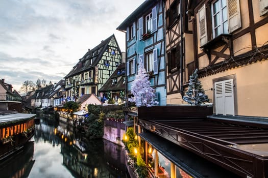 Street above a canal in the French city of Colmar. Old typical colorful architecture at sunset.