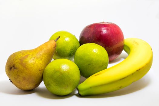 Red apple, banana, three lime and a pear all looking very natural not perfect but still shiny and tasty !