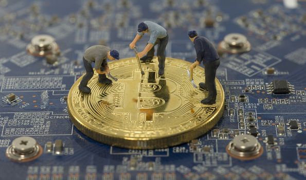 little world figures mining bitcoins on electronic print plate
