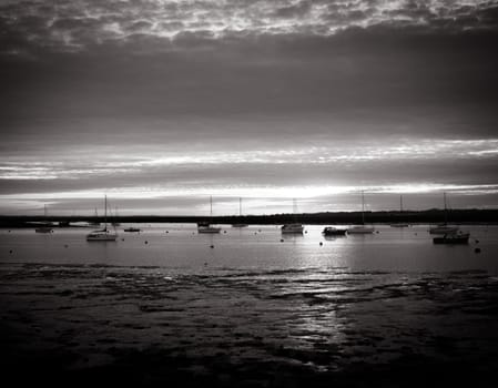 beautiful silver black and white coast sunset cloudy scene estuary boats; essex; england; uk