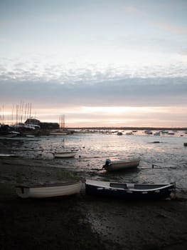 sunset over moored private wooden boats on coastline shore; essex; england; uk