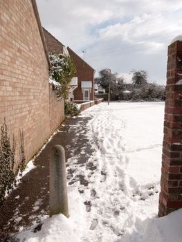 walkway behind houses through uk estate snowy winter day; essex; england; uk