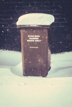 Snow Lying On A Recycling Wheelie Bin (Trash Can) In The UK During A Snow Storm With Copy Space