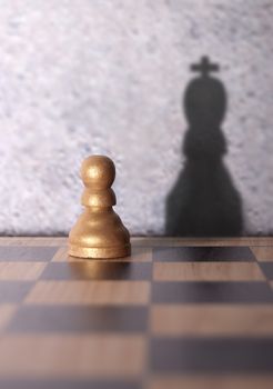 Chess king shadow emerging from a pawn