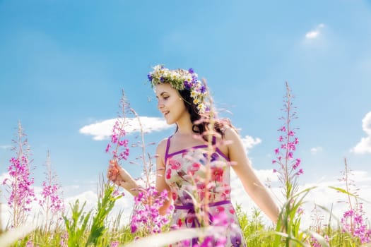 Portrait of the beautiful girl in the field in flowers