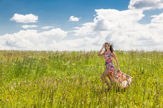 Portrait of the beautiful girl running in the field