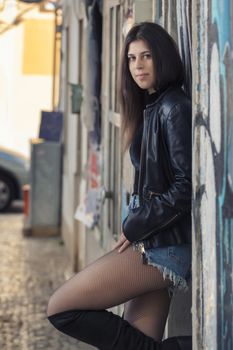 Close view of a beautiful young woman with classic guitar on the streets of the city.