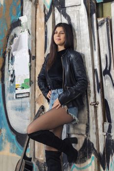 Close view of a beautiful young woman with classic guitar on the streets of the city.