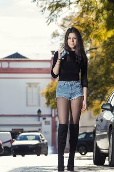 Close view of a beautiful young woman with classic guitar on the streets of the city.