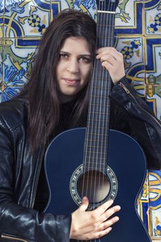 Close view of a beautiful young woman with classic guitar on the streets of the city.