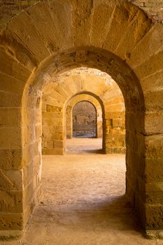 Italy - Old castle of Syracuse in Siciliy. Archs made of stone in perspective.